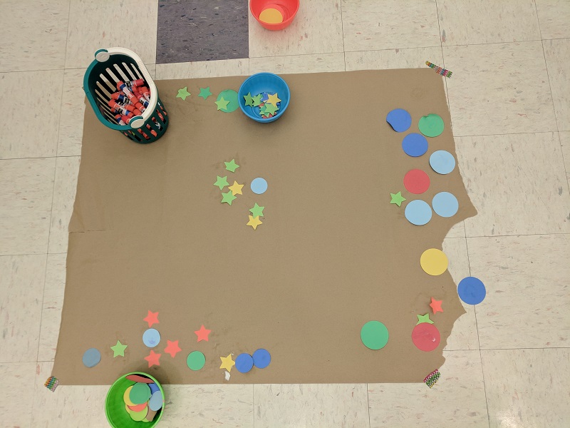 Craft: gluing colored paper shapes to butcher paper