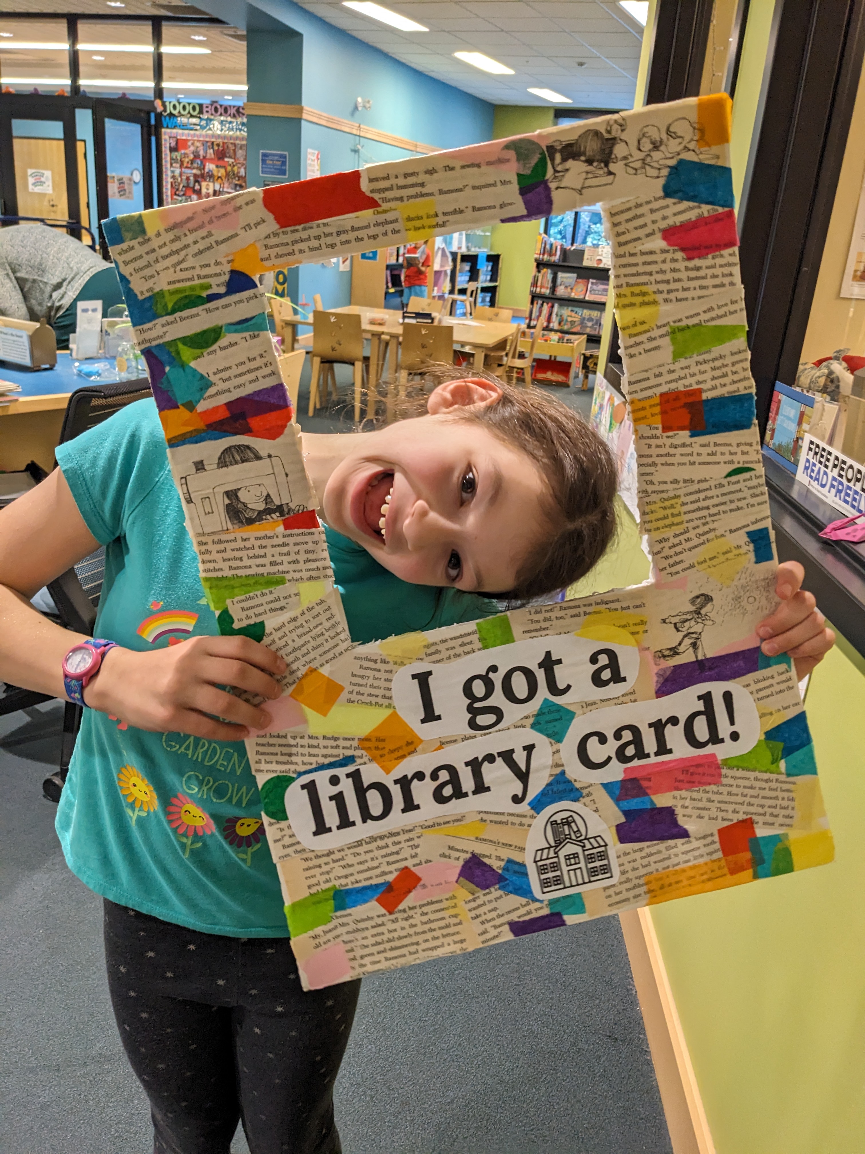 Kid holding "I got a library card" photo frame
