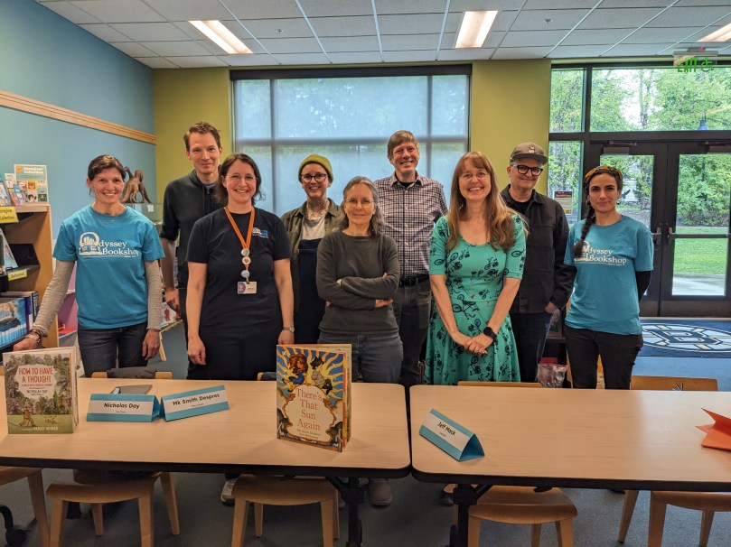 Booksellers, authors, and librarian lined up behind a table